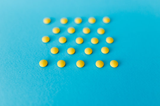Scattered white pills on blue table. Mock up for special offers as advertising, web background or other ideas. Medical, pharmacy and healthcare concept. Empty place for text or logo.