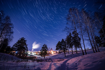 Star Trails in the Night Winter Sky above the Village