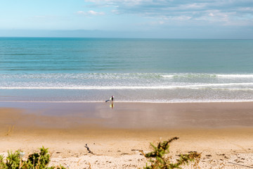 Fototapeta na wymiar Lonely Surfer on sand beach 