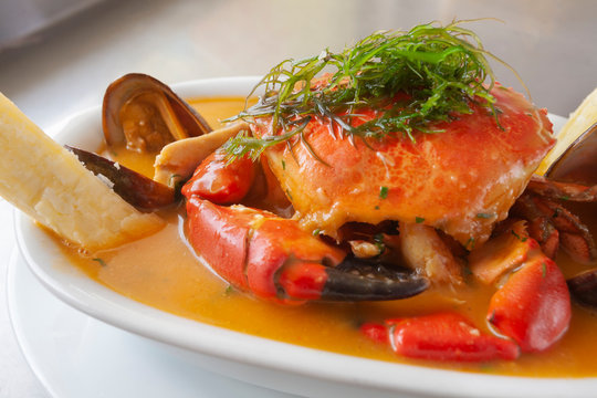 Peruvian seafood: Parihuela or special seafood soup with crab, mussels and cassava, decorated with seaweed and served on a white bowl