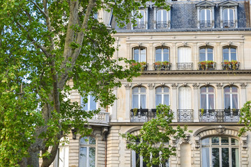 Facade of a house in Paris. The classic building of European architecture. Summer day, sunlight