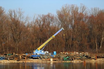crane on a car standing on the banks of the river