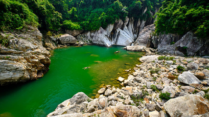 Fototapeta na wymiar View of the rocks and emerald water at the waterfall in Sapa vietnam
