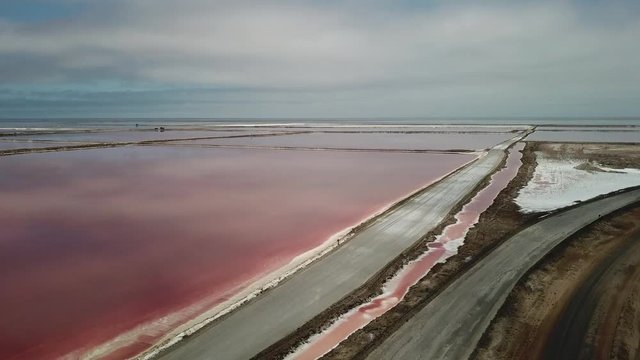 4K aerial drone video of salt works factory wide pink salty water evaporation ponds, in outskirts of coastal harbour town Walvis Bay, Namib Desert, Atlantic Ocean west coast, Namibia, southern Africa
