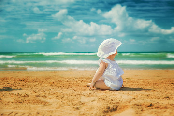 little girl sitting on the beach