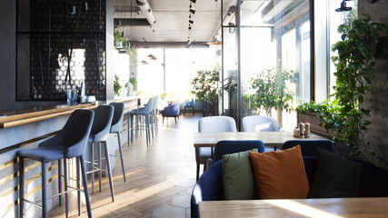 Light modern interior of urban restaurant or cafe with dining places