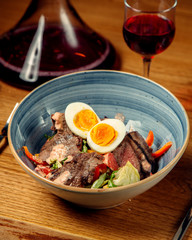 a bowl of meat salad with lettuce bell peppers grapefruit sauce vertical photo