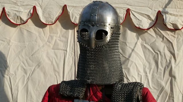 Medieval old knight helmet and chain mail for protection in battle. Very heavy headdress on stand. Middle ages armor concept. Close up, selective focus