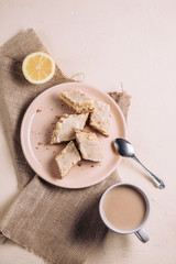 Cottage cheese cheesecake slices on a plate, breakfast with tea and lemon, top view