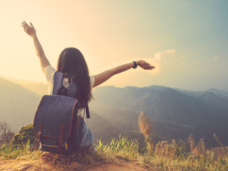 solo woman with backpack sitting to enjoy the view complex mountains in tropical forest. vintage...