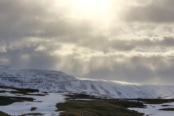 Dark asphalt road on the background of mountains and ocean. The tour around Iceland. Geothermal heat this way