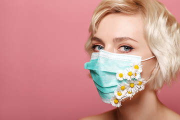 Woman wearing protective face mask with flower application. Spring beauty conception due the quarantine of coronavirus outbreak. Copy, empty space for text