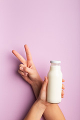 Vegetarian healthy drink on coconut milk, woman showing v sign