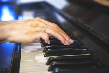 Girls hands on  keyboard of piano. girl plays piano,close up piano. Hands on the white keys of the...