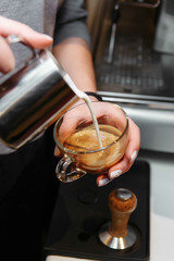 Fototapeta na wymiar Barista pours milk making cappuccino or latte. Drawing on pen.