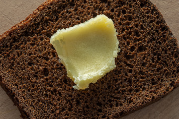 Ghee on a piece of coarse rye bread. Healthy foods.