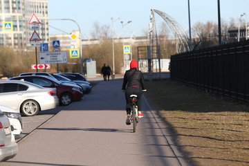 Healthy lifestyle - young woman in red hat biking