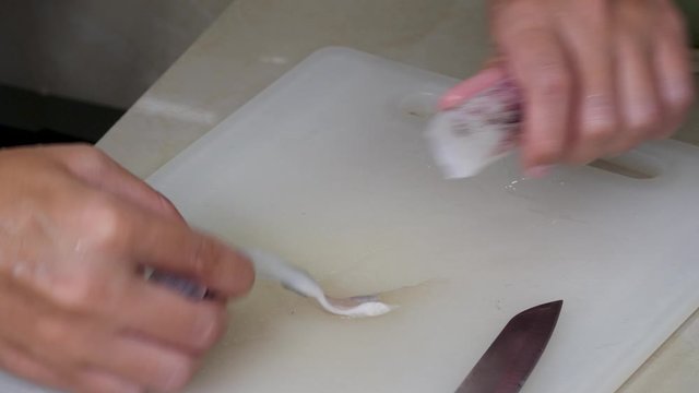 Housewife cook raw squid on home kitchen board. Fresh cuttlefish