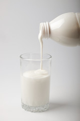Kefir drink in a bottle and glass on a white background.Sour milk drink