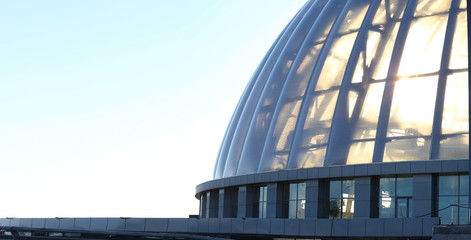 Large glass dome against a light sunset sky. Modern architecture. Fragment of a building close-up. © Alexandr