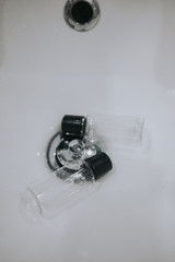 empty shampoo jars in the sink