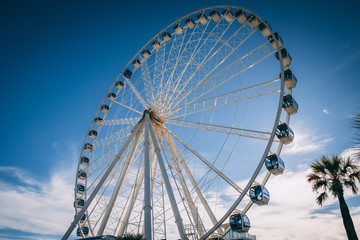 big ferris wheel in front of blue sky with clouds