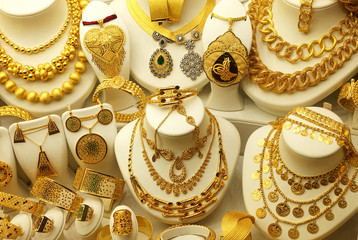 Many beautiful gold jewelry on coasters. Various necklaces, chains, earrings and bracelets          