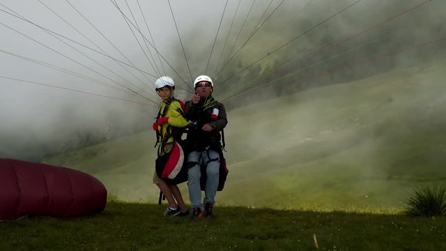Father and son have vacations together doing paragliding high in mountains.