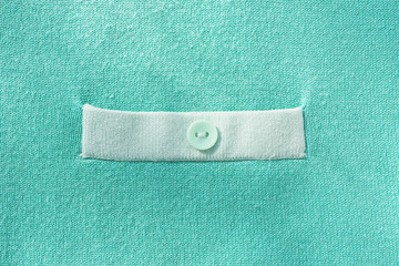 Abstract background and texture of a knitted fabric of mint blue and in the middle a white strip with a button...