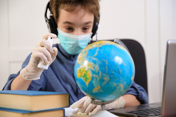 schoolboy in medical mask studying at home. Distance learning online education, coronavirus quarantine