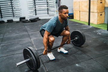 Fototapeta na wymiar Crossfit athlete doing exercise with a barbell.
