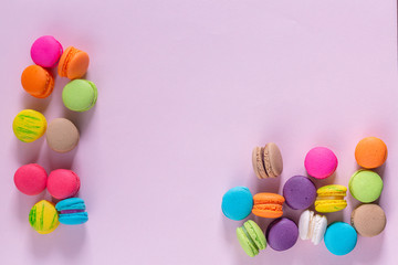 Multicolored macaroons on pink background