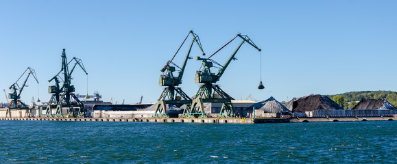 Cranes and piles of coal in a coal port in Gdynia, Poland.