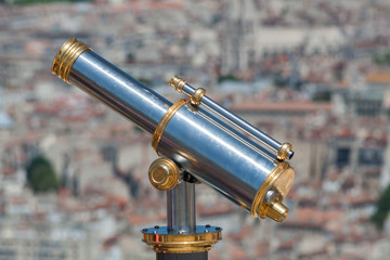 Fototapeta na wymiar metal telescope with city in the background