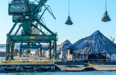 Cranes and piles of coal in a coal port in Gdynia, Poland.