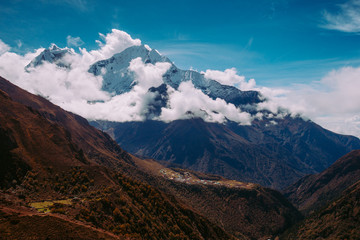 Snow covered beautiful mountain peaks and soft white clouds