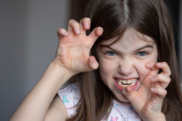 Fototapeta premium little girl feels negative emotions, grimace on her face, teases