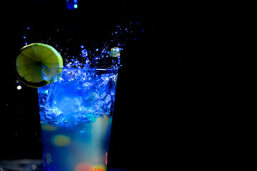 glass, drink, cocktail, water, alcohol, splash, ice, green, cold, beverage, liquid, martini, blue, splashing, isolated, lemon, vodka, party, lime, black, refreshment, white, wet, cool, fruit