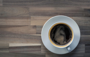 Hot black coffee cup on wooden with copyspace for text.