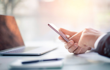 businessman using smart phone and laptop in office