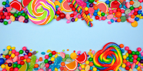 Colorful selection of candies. Top view double border with a blue banner background.