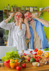 Handsome man and woman laughing and wearing glasses of paprika