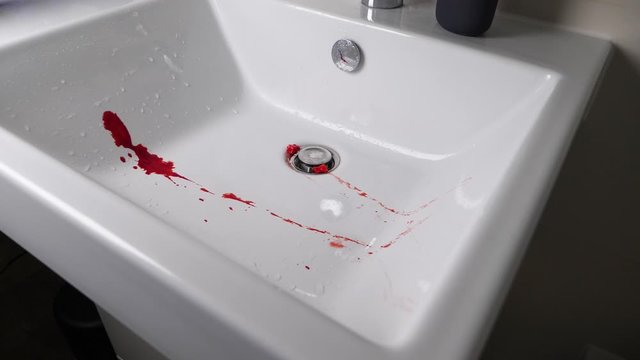 Blood flows into sink then two bloody teeth fall blook splattering. 