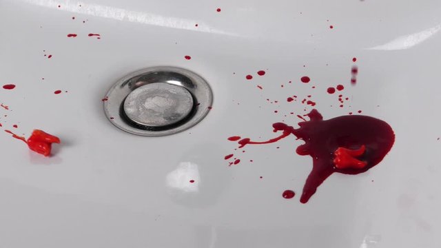 Blood flows into sink then two bloody teeth fall blook splattering. Close up