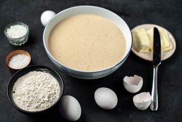 The recipe for making homemade pancakes from
flour, eggs, butter, milk, salt, sugar on a stone background