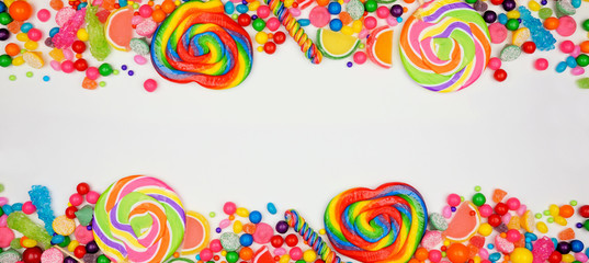 Colorful assorted candies. Above view double border with a white banner background.