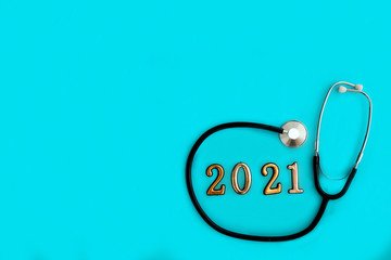 Stethoscope with 2021 number on blue background. Happy New Year for health care and medical banner/calendar cover. Top view , copy space.