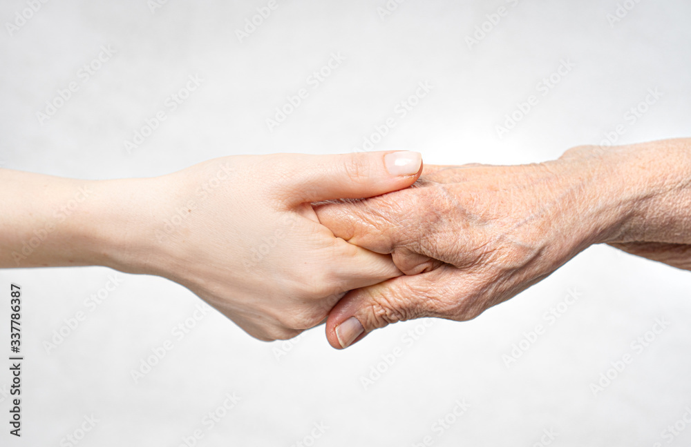 Wall mural helping hand for the elderly concept with young hand holding old hand.