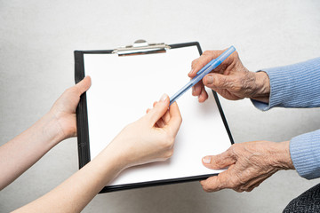 Giving paper and pen to elderly parent. Helping elderly people concept.