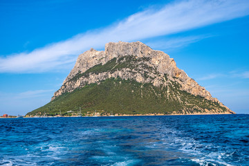 Fototapeta na wymiar Panoramic view of cliffs and slopes of main limestone massif, Monte Cannone peak, of Isola Tavolara island on Tyrrhenian Sea off northern coast of Sardinia, Italy